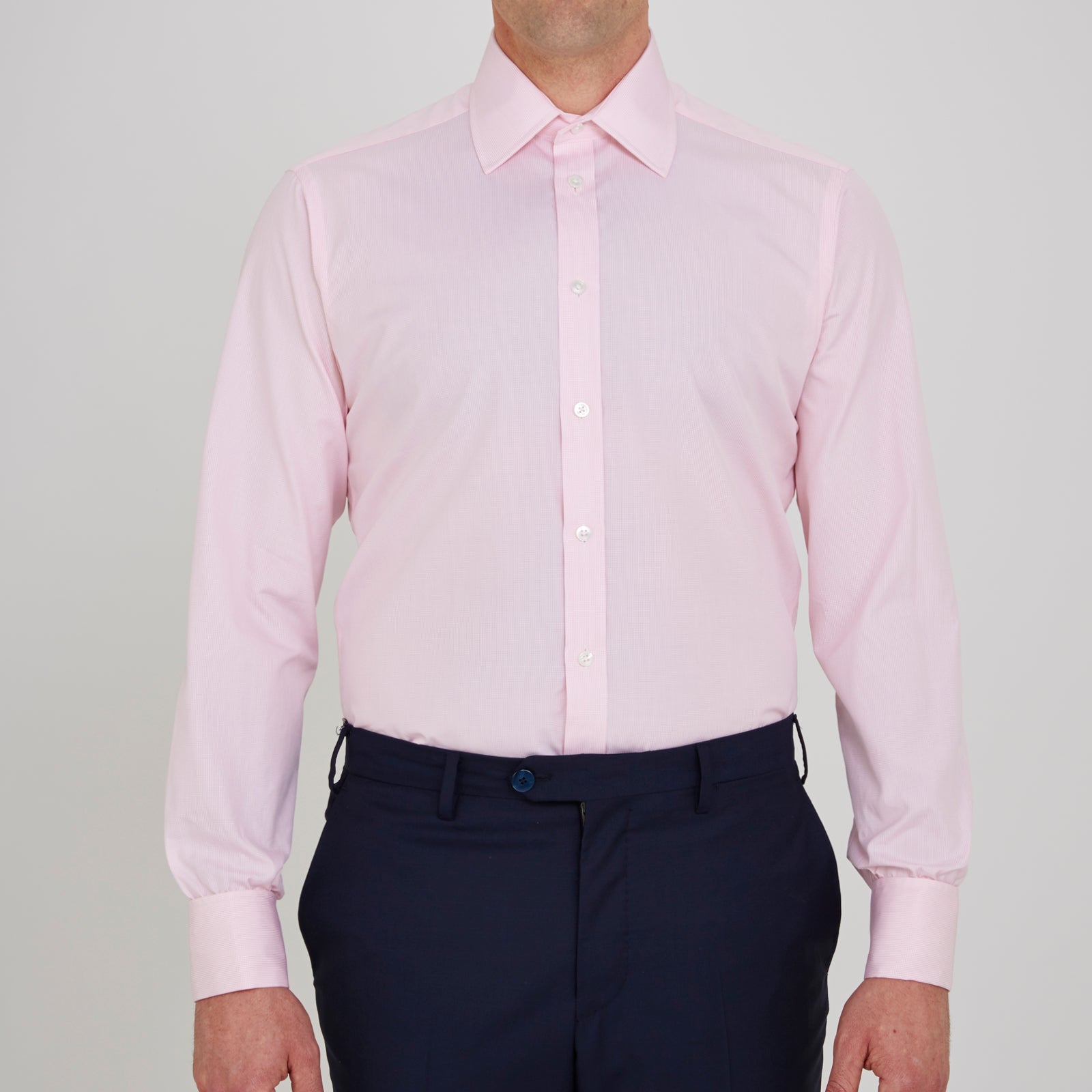 View 2 of product The Turnbull & Asser Pink Fine Check Shirt features a T&A collar, double cuffs, and classic white buttons, neatly folded and displayed against a plain white background.