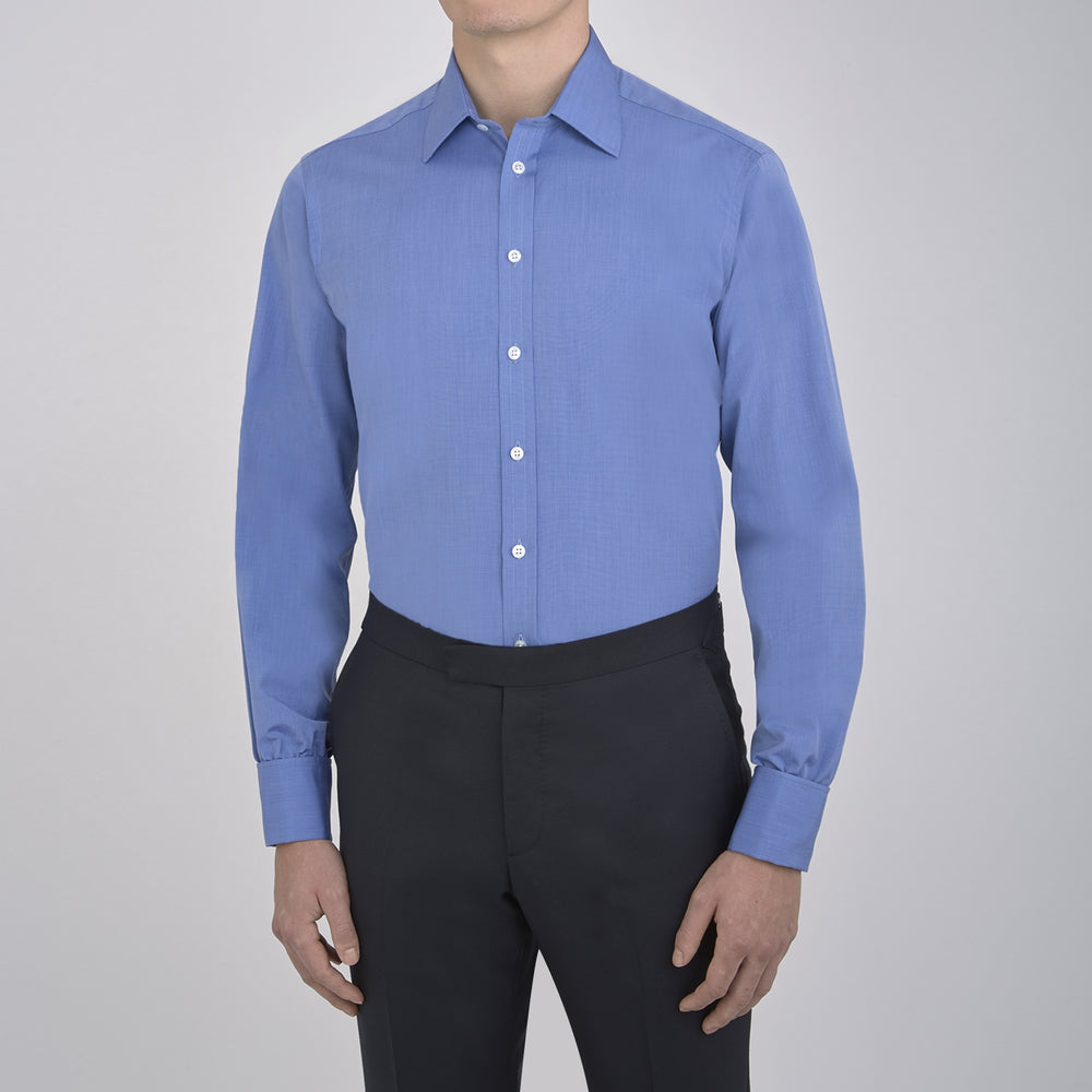 A neatly folded, dark blue end-on-end men's dress shirt by Turnbull & Asser, featuring a T&A collar and double cuffs, is displayed against a plain white background.