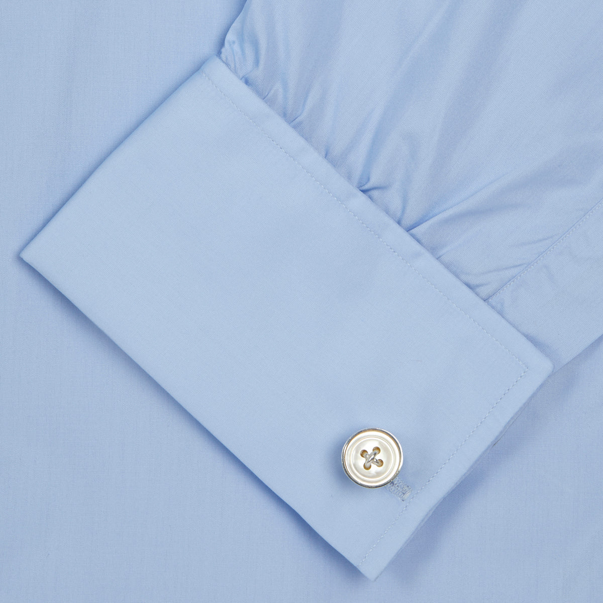 View 6 of product The Turnbull & Asser Two-Fold 200 Blue Cotton Shirt features a T&A collar, double cuffs, white buttons, and a visible label inside the collar, displayed neatly folded on a plain white background for superior breathability.