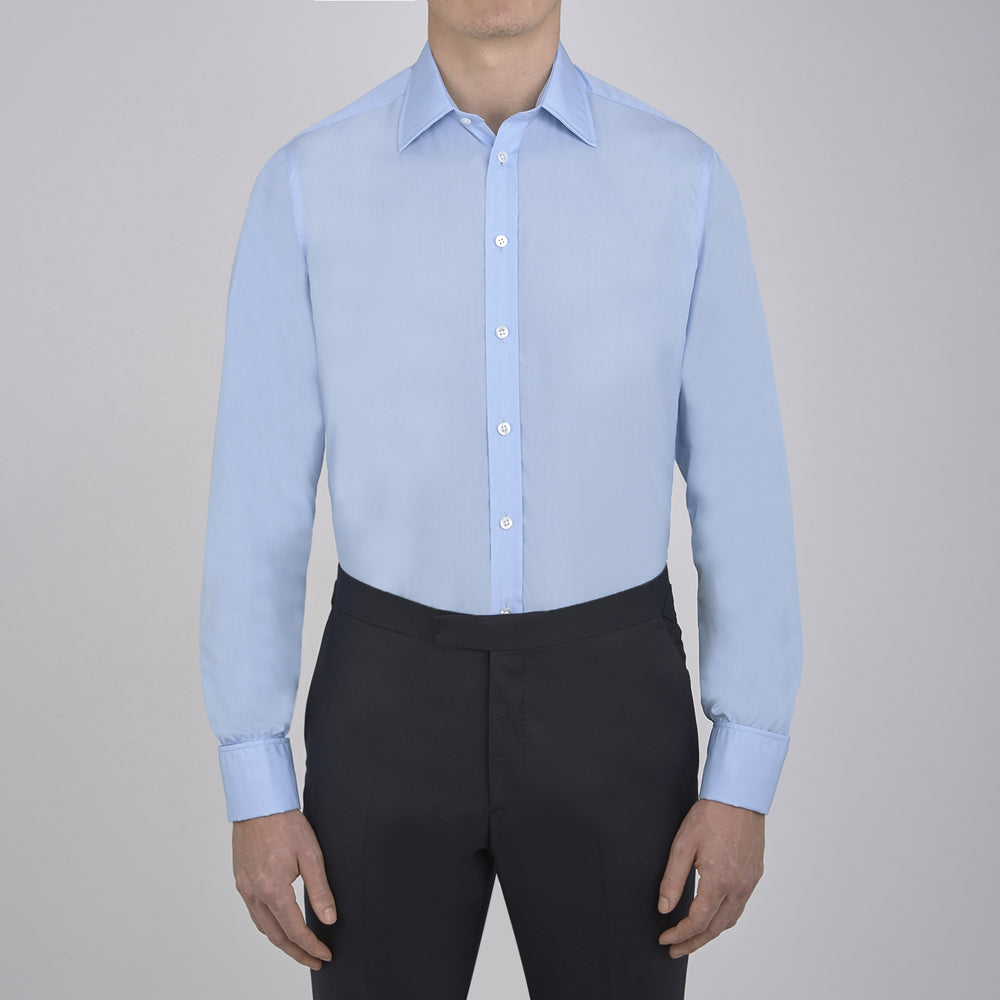 The Turnbull & Asser Two-Fold 200 Blue Cotton Shirt features a T&A collar, double cuffs, white buttons, and a visible label inside the collar, displayed neatly folded on a plain white background for superior breathability.