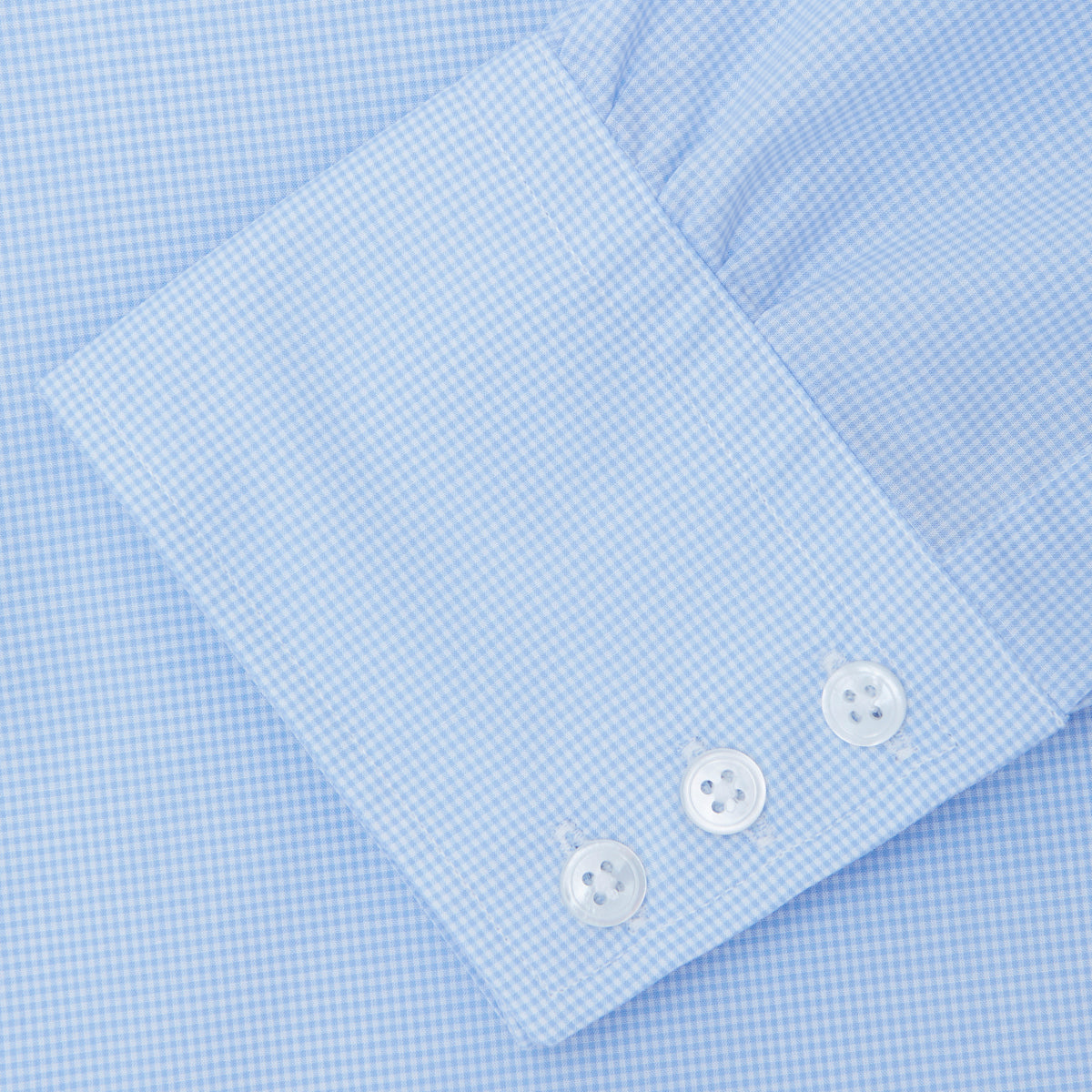 View 6 of product The Sky Blue Micro-Check Cotton Shirt by Turnbull & Asser features a T&A collar and 3-button cuffs, offering a refined take on classic British style. The shirt is neatly folded, showcasing its signature elegance against a white background.