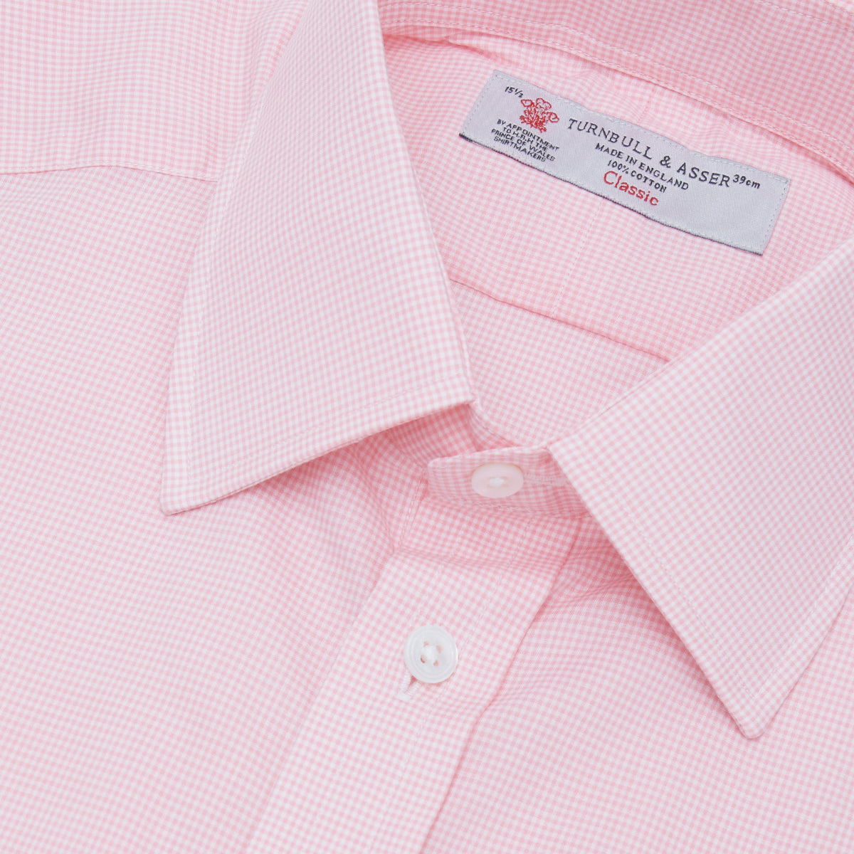 View 5 of product The Turnbull & Asser Pink Micro-Check Cotton Shirt features a T&A collar, 3-button cuffs, and a refined micro-check pattern, shown neatly folded against a white background.