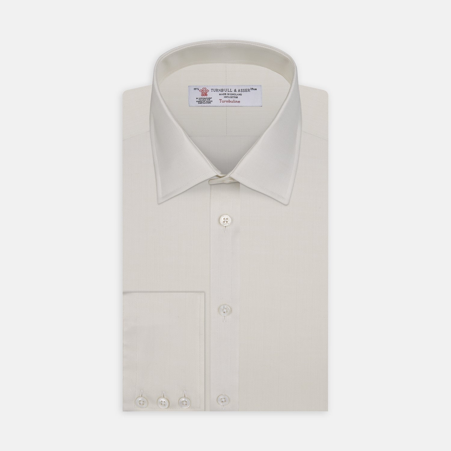 View 1 of product The Turnbull & Asser Cream Herringbone Superfine Cotton Shirt features a T&A collar and 3-button cuffs, ideal for minimalist style or bold ties, shown neatly folded against a plain white background.