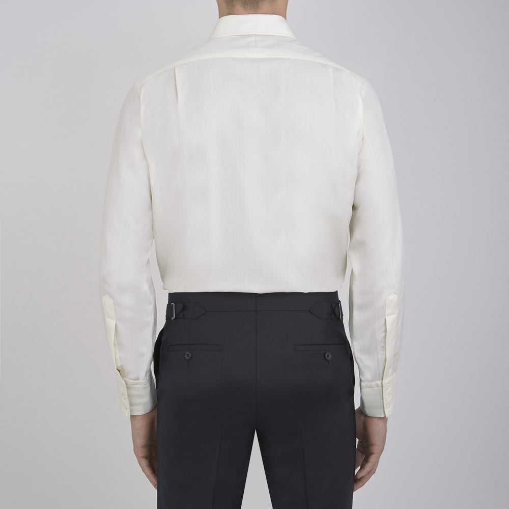 The Turnbull & Asser Cream Herringbone Superfine Cotton Shirt features a T&A collar and 3-button cuffs, ideal for minimalist style or bold ties, shown neatly folded against a plain white background.
