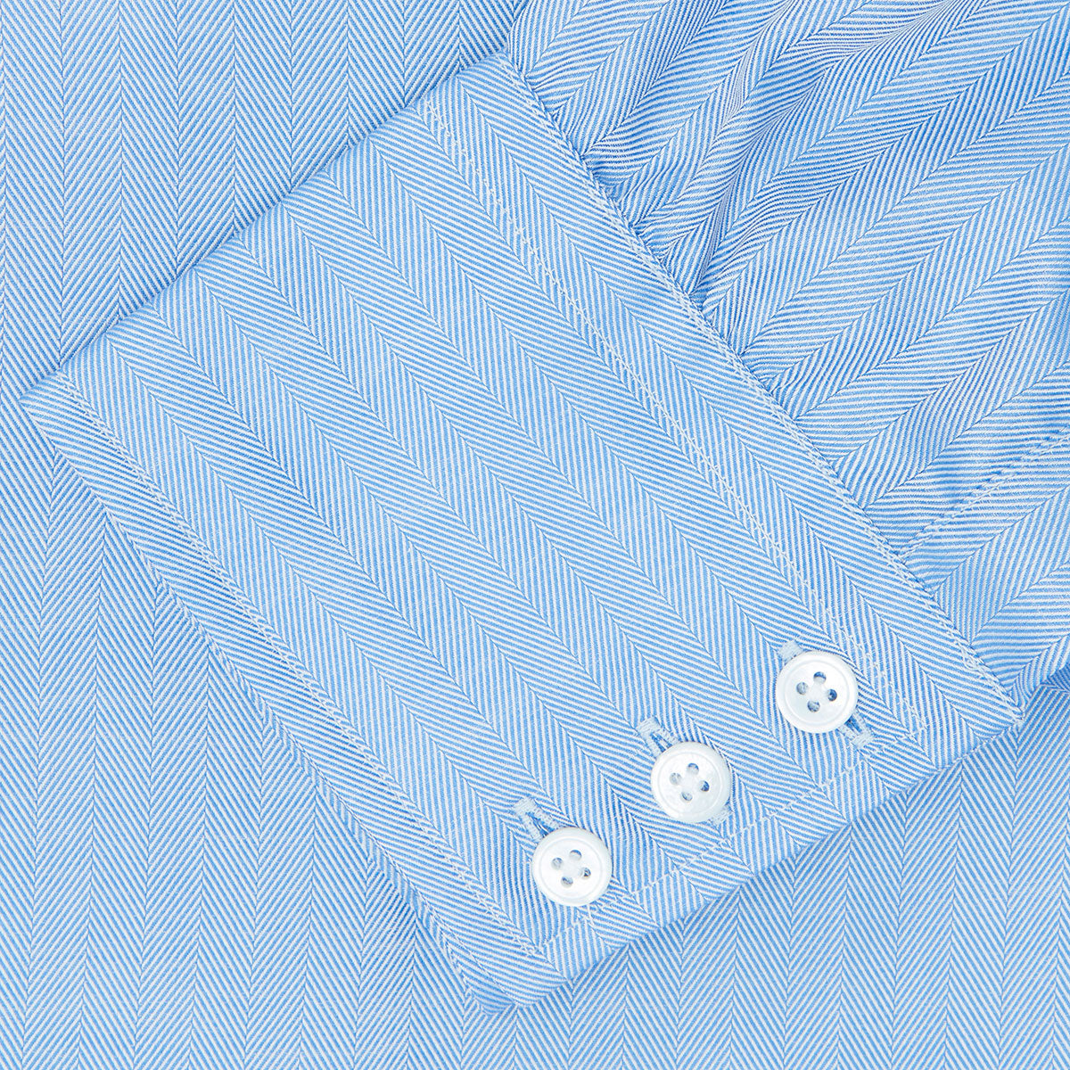 View 6 of product The Blue Herringbone Superfine Cotton Shirt by Turnbull & Asser features a T&A collar and 3-button cuffs, offering a refined minimalist look. Displayed against a plain white background.