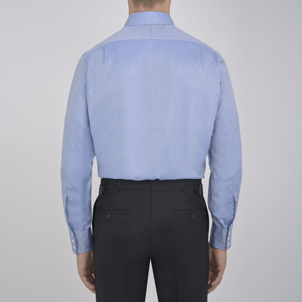 The Blue Herringbone Superfine Cotton Shirt by Turnbull & Asser features a T&A collar and 3-button cuffs, offering a refined minimalist look. Displayed against a plain white background.