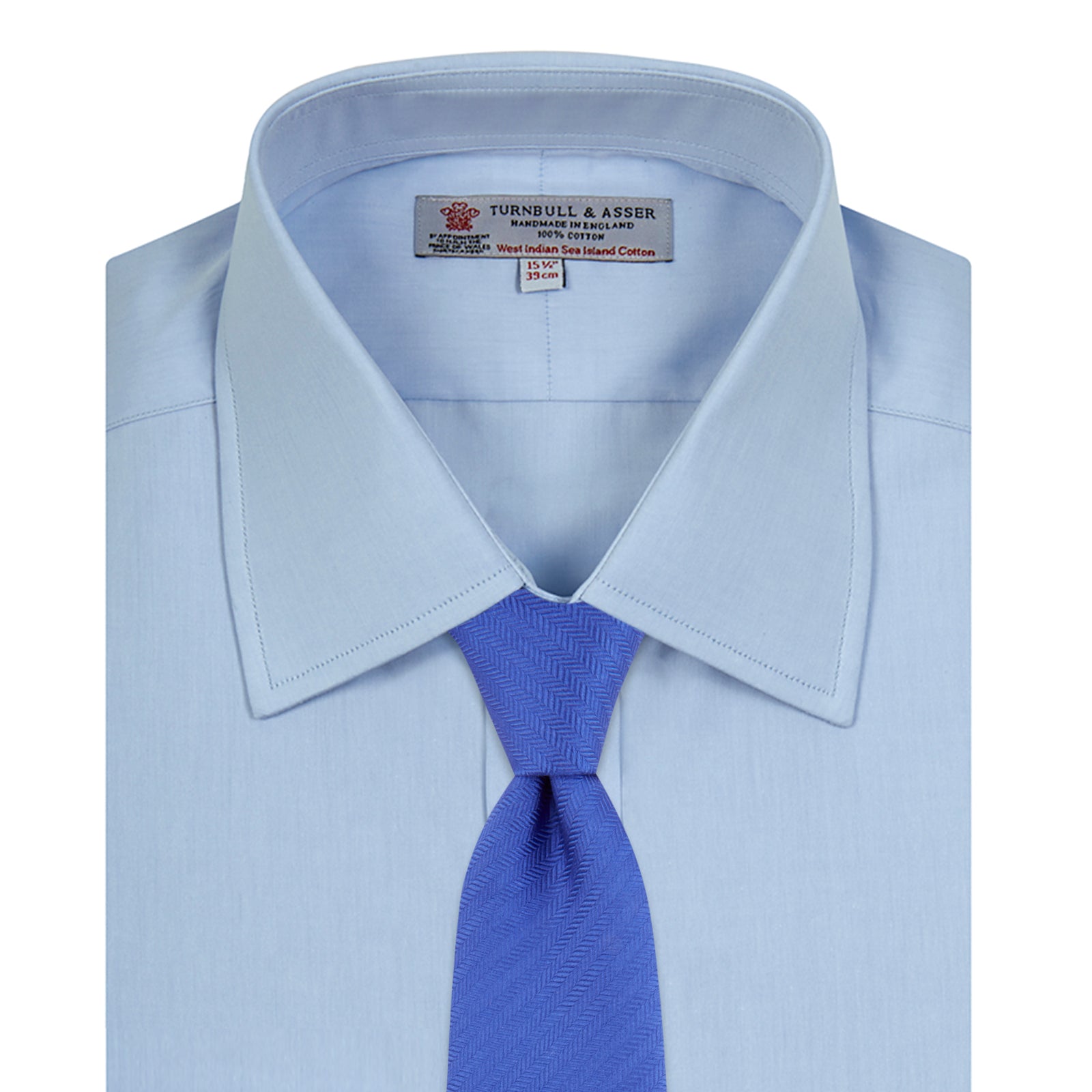 View 4 of product A neatly folded light blue long-sleeve dress shirt with a pointed collar and white buttons, styled with the Turnbull & Asser Monochrome Paisley Mill Silk Pocket Square (limited edition), displayed against a plain white background.