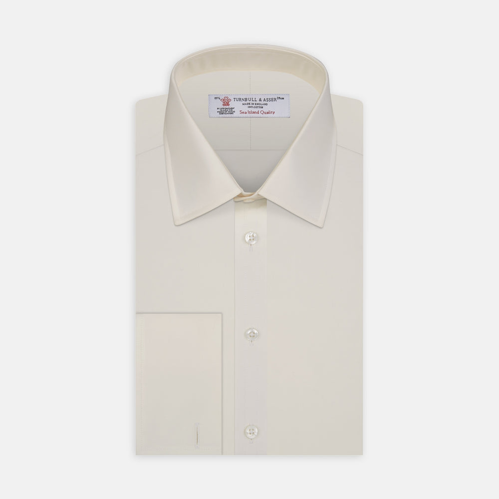 The Turnbull & Asser Cream Sea Island Quality Cotton Shirt features a T&A collar, double cuffs, and a button-down front, elegantly displayed against a white background.