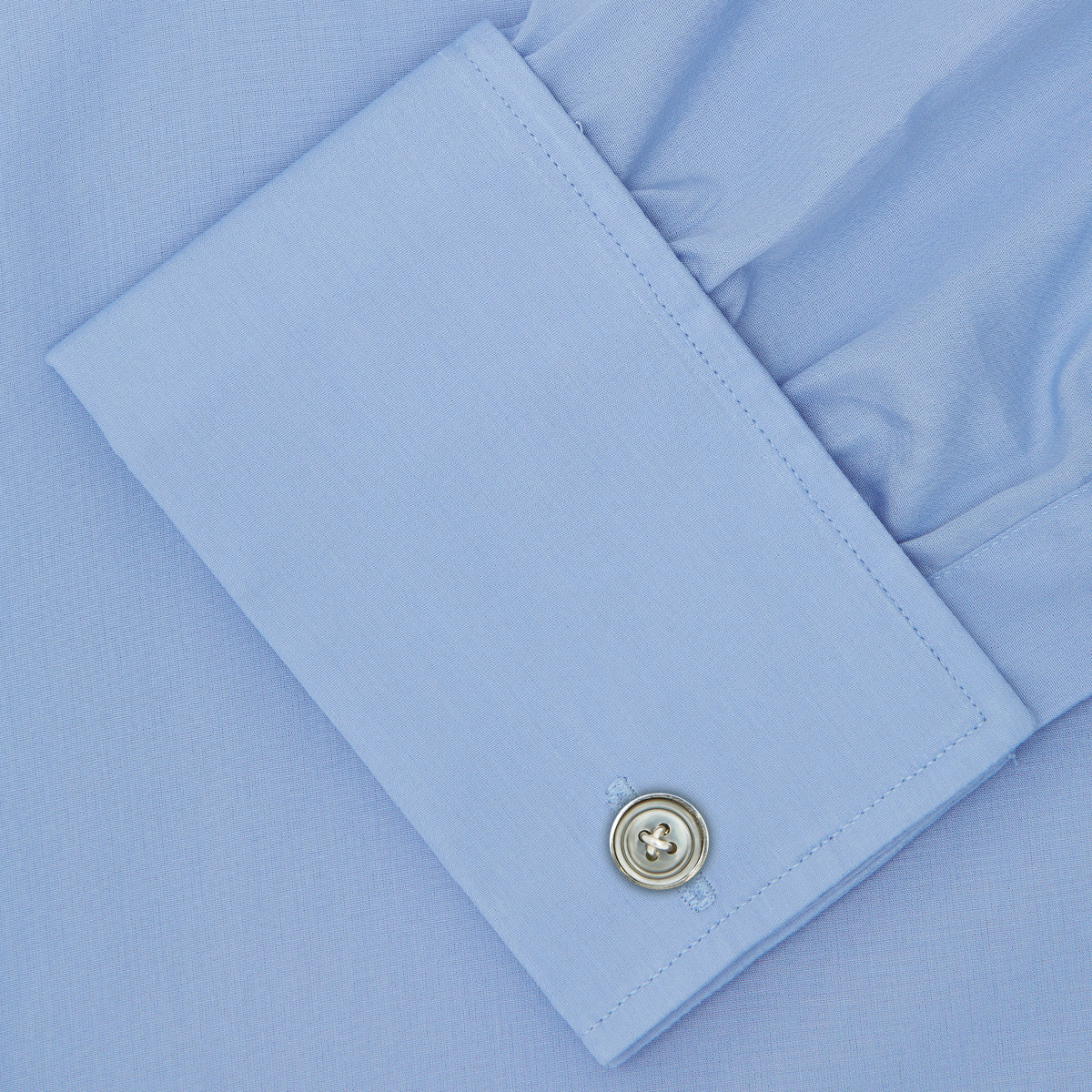 View 6 of product The Turnbull & Asser Blue Sea Island Quality Cotton Shirt features a T&A collar, double cuffs, and is showcased neatly folded on a plain white background.
