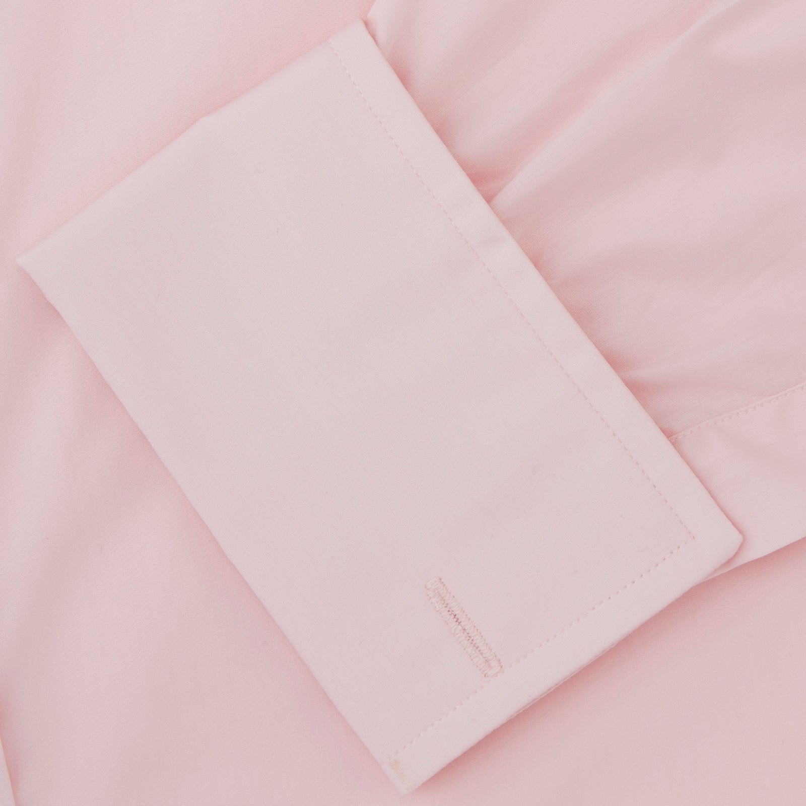 View 6 of product A slim black herringbone silk tie by Turnbull & Asser is paired with a neatly folded light pink long-sleeve dress shirt with a classic collar and white buttons, all displayed on a plain white background.