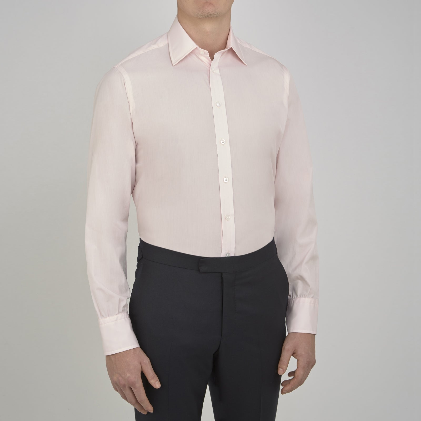 View 2 of product A slim black herringbone silk tie by Turnbull & Asser is paired with a neatly folded light pink long-sleeve dress shirt with a classic collar and white buttons, all displayed on a plain white background.