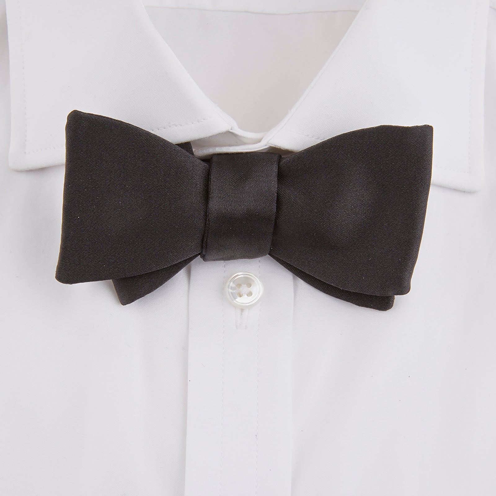 View 2 of product The Turnbull & Asser Black Silk Bow Tie features a matte finish and classic design, ideal for formal occasions. Shown pre-tied against a plain white background.