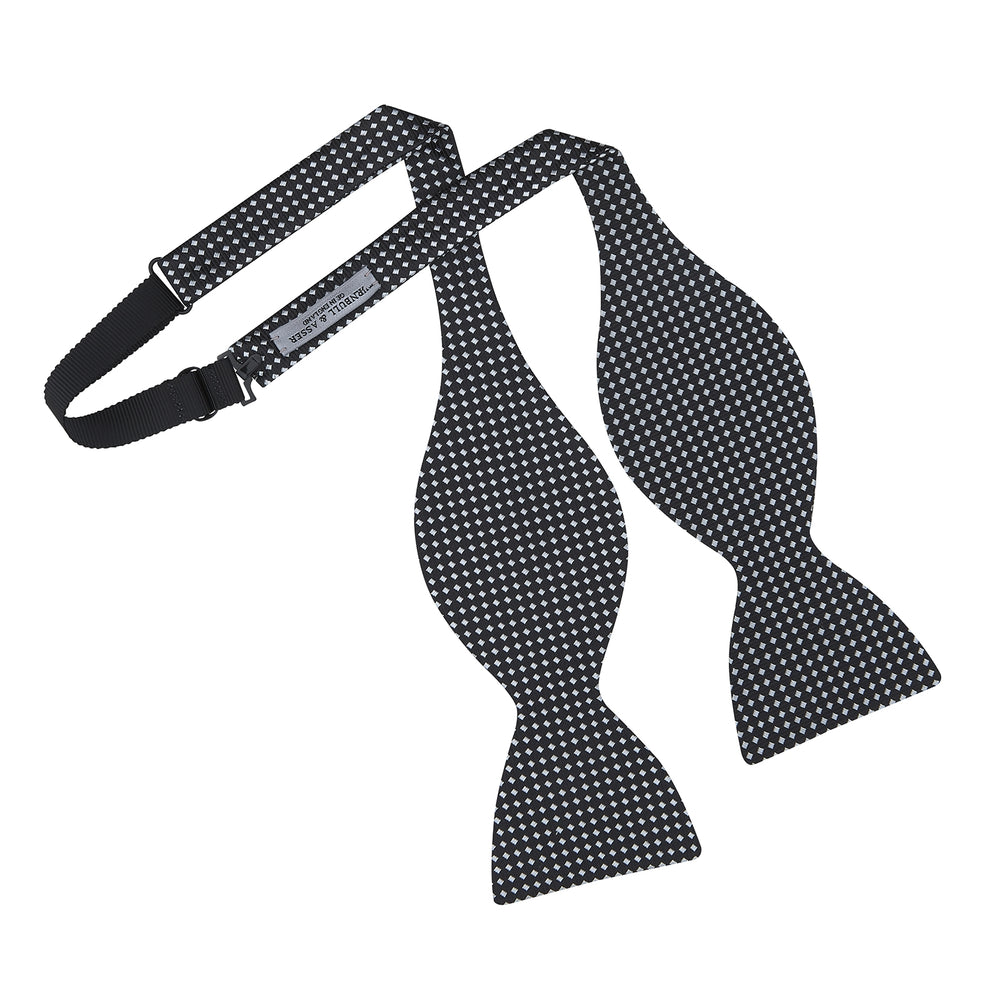 The Turnbull & Asser Diamond Black and White Silk Bow Tie features a black woven silk design with a tessellated diamond pattern of small white shapes, shown against a plain white background.