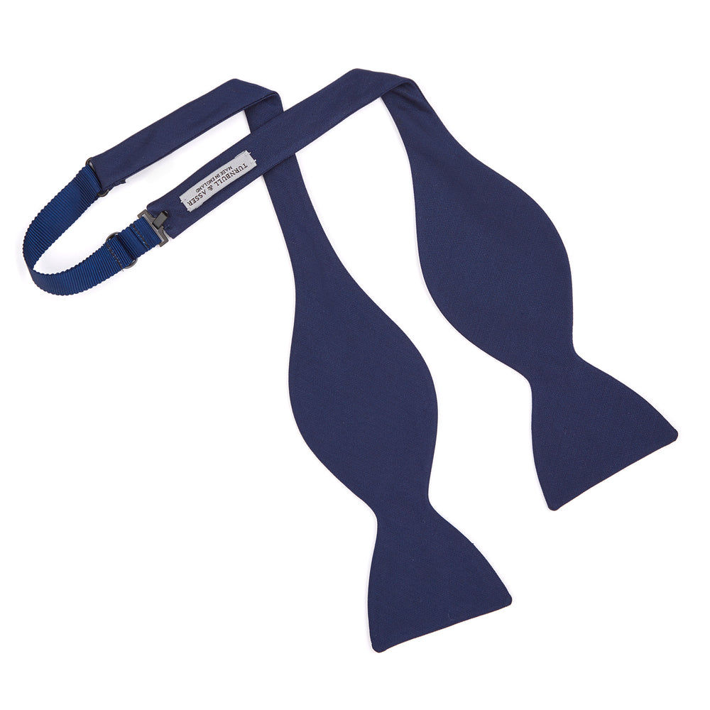 The Turnbull & Asser Navy Barathea Bow Tie features a classic butterfly shape in deep blue silk, ideal for formal occasions, shown against a white background.