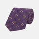 The Turnbull & Asser Purple Crosses Silk Tie features a rolled-up purple design with small yellow and black cross motifs on silk.
