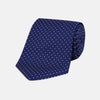 View 1 of product The Blue and White Small Spot Printed Silk Tie by Turnbull & Asser, shown rolled on a white background, features a refined white polka dot pattern—ideal for complementing any office shirt.