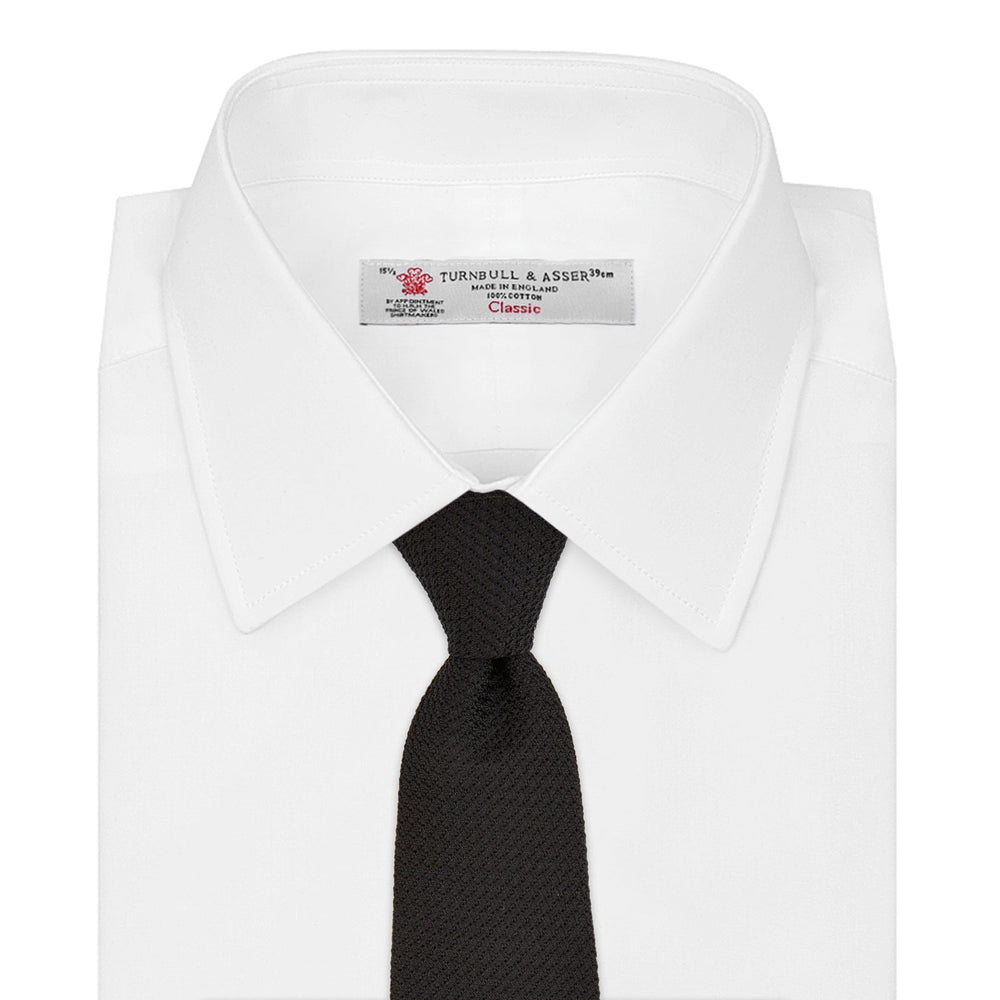 The Turnbull & Asser Black Grenadine Silk Tie features a refined textured look and dimensional stability thanks to its subtle grenadine weave, shown here on a white background.