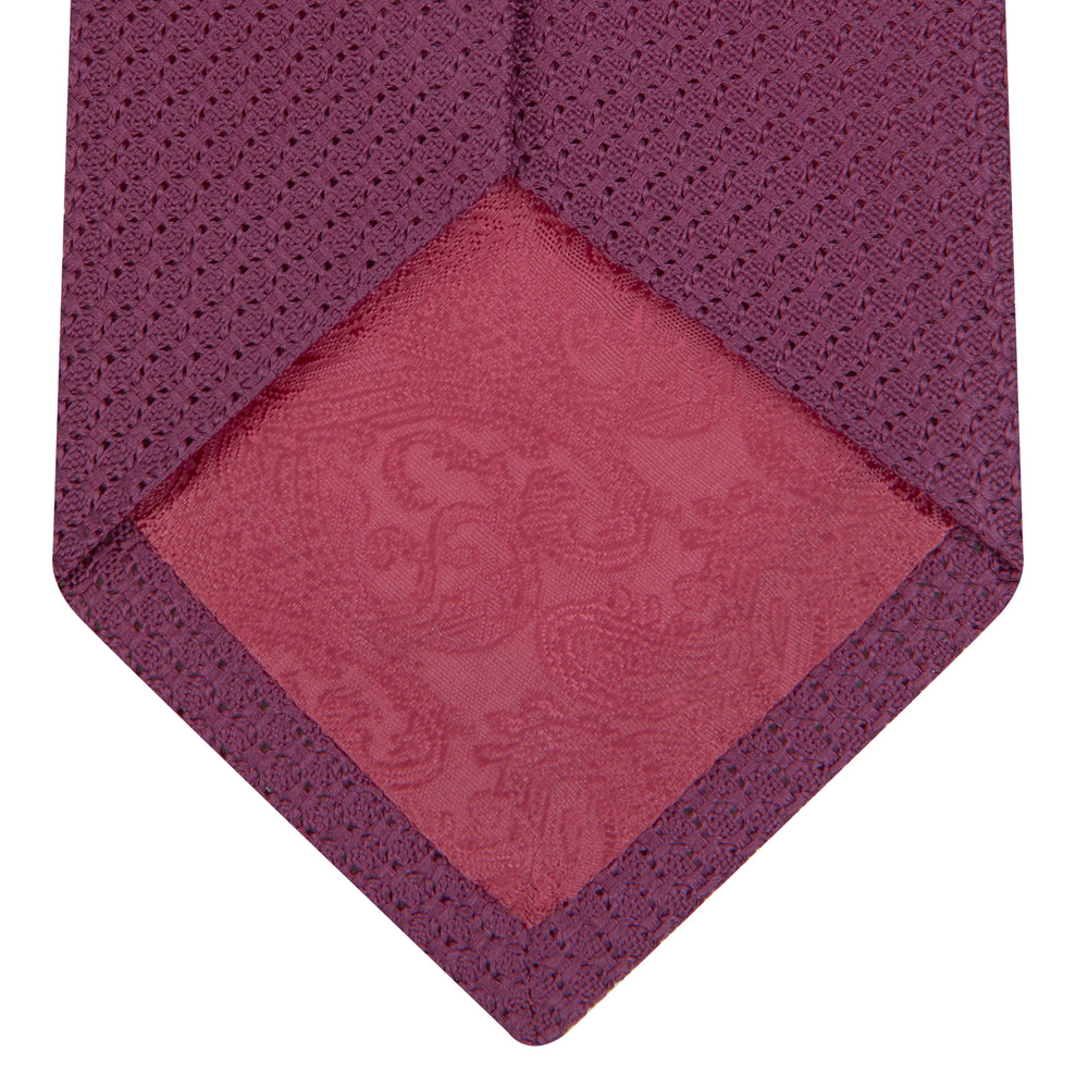 The Turnbull & Asser Wine Grenadine Silk Tie, featuring a textured weave in dark purple, is displayed rolled-up on a plain white background.