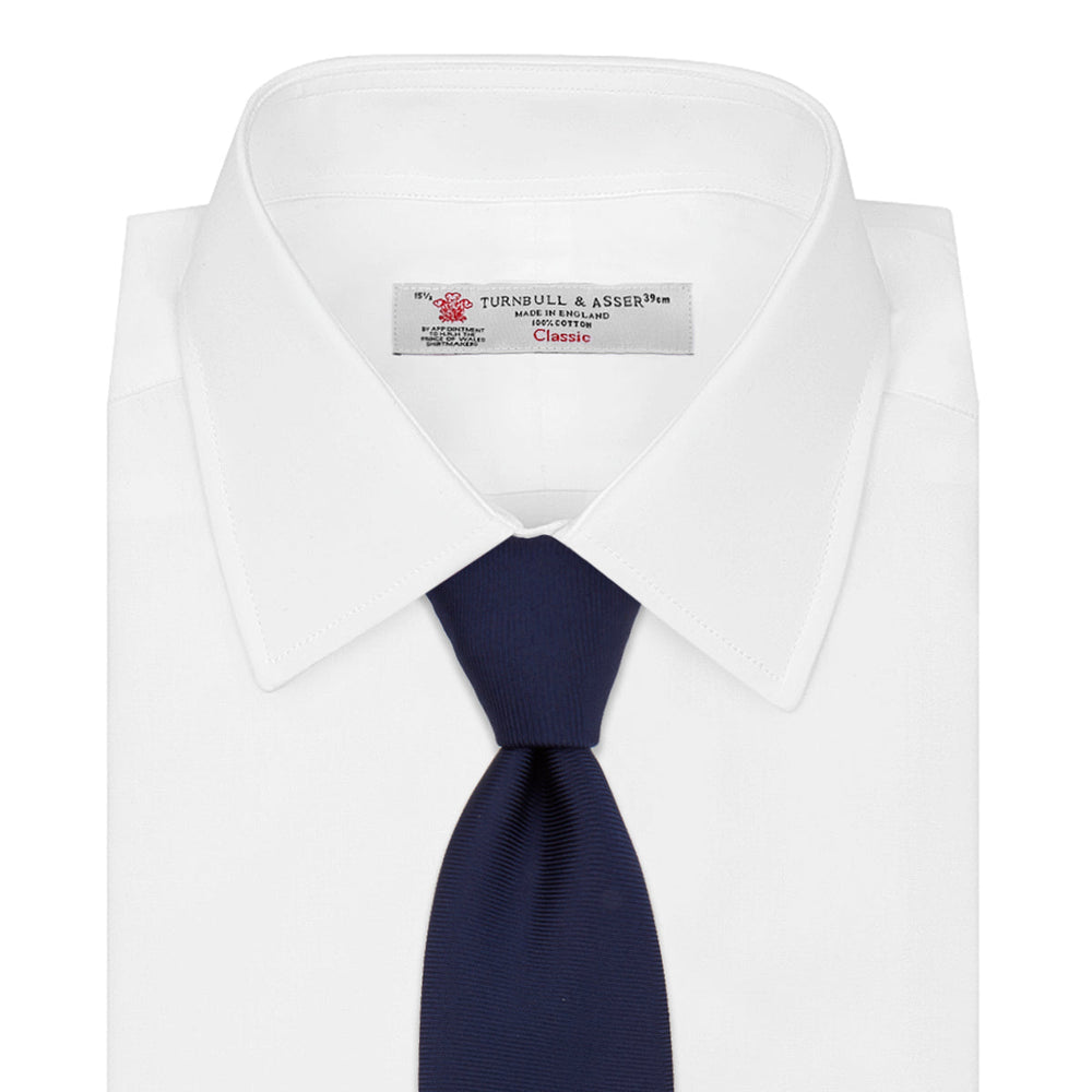 The Turnbull & Asser Navy Horizontal Twill Silk Tie features a subtle textured pattern and is elegantly displayed on a plain white background—ideal for pairing with cotton shirts for a smart, refined look.