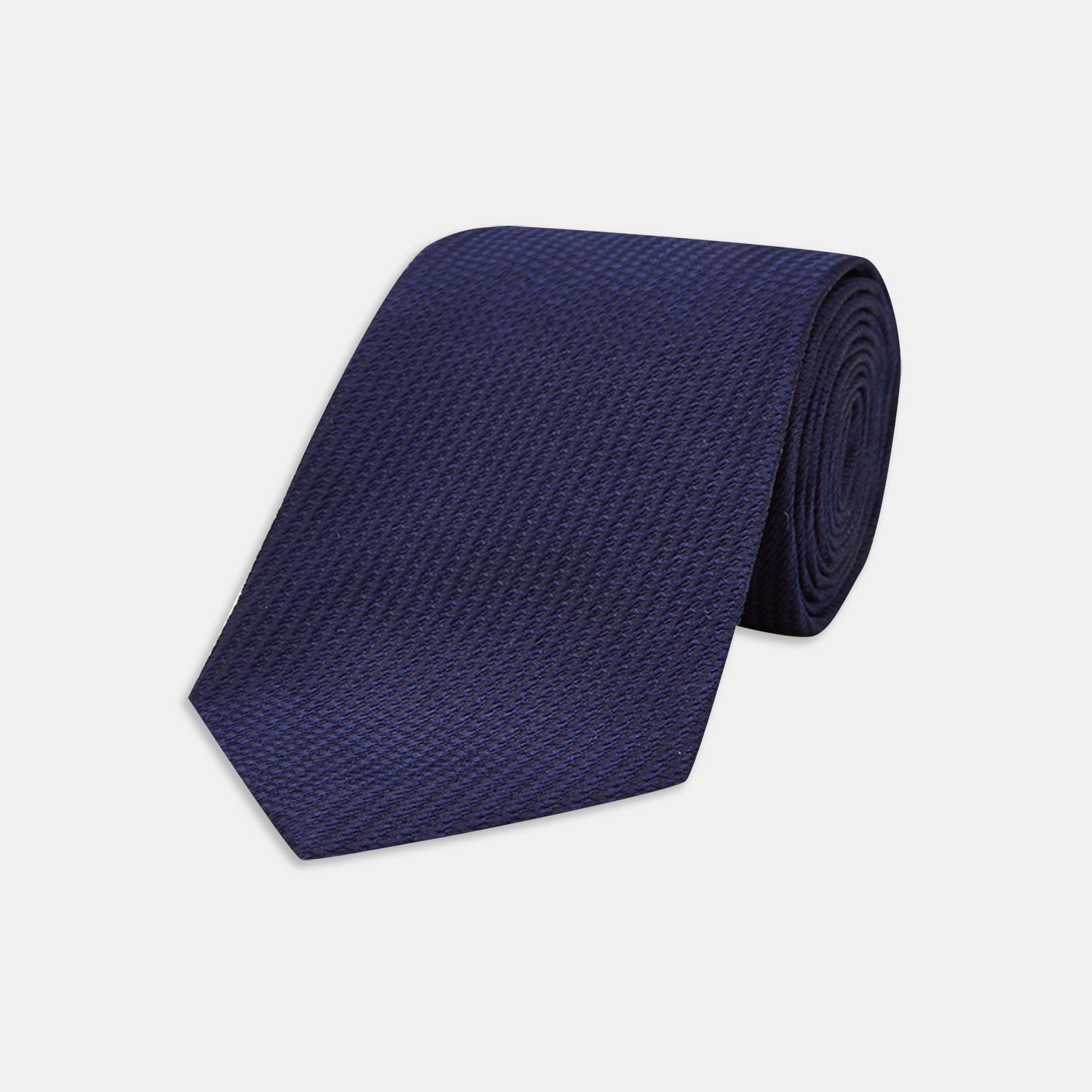 View 1 of product The Turnbull & Asser Navy Lace Silk Tie, featuring a subtle lace weave texture, is displayed rolled up on a plain white background.