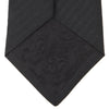 View 4 of product A Long Black Herringbone Silk Tie by Turnbull & Asser is shown rolled up on a plain white background.