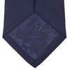View 4 of product The Turnbull & Asser Long Navy Plain Satin Silk Tie is neatly rolled and displayed against a plain white background.