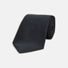 View 1 of product The Turnbull & Asser Black Plain Satin Silk Tie, neatly rolled and shown on a white background, adds versatile elegance to any formal outfit.