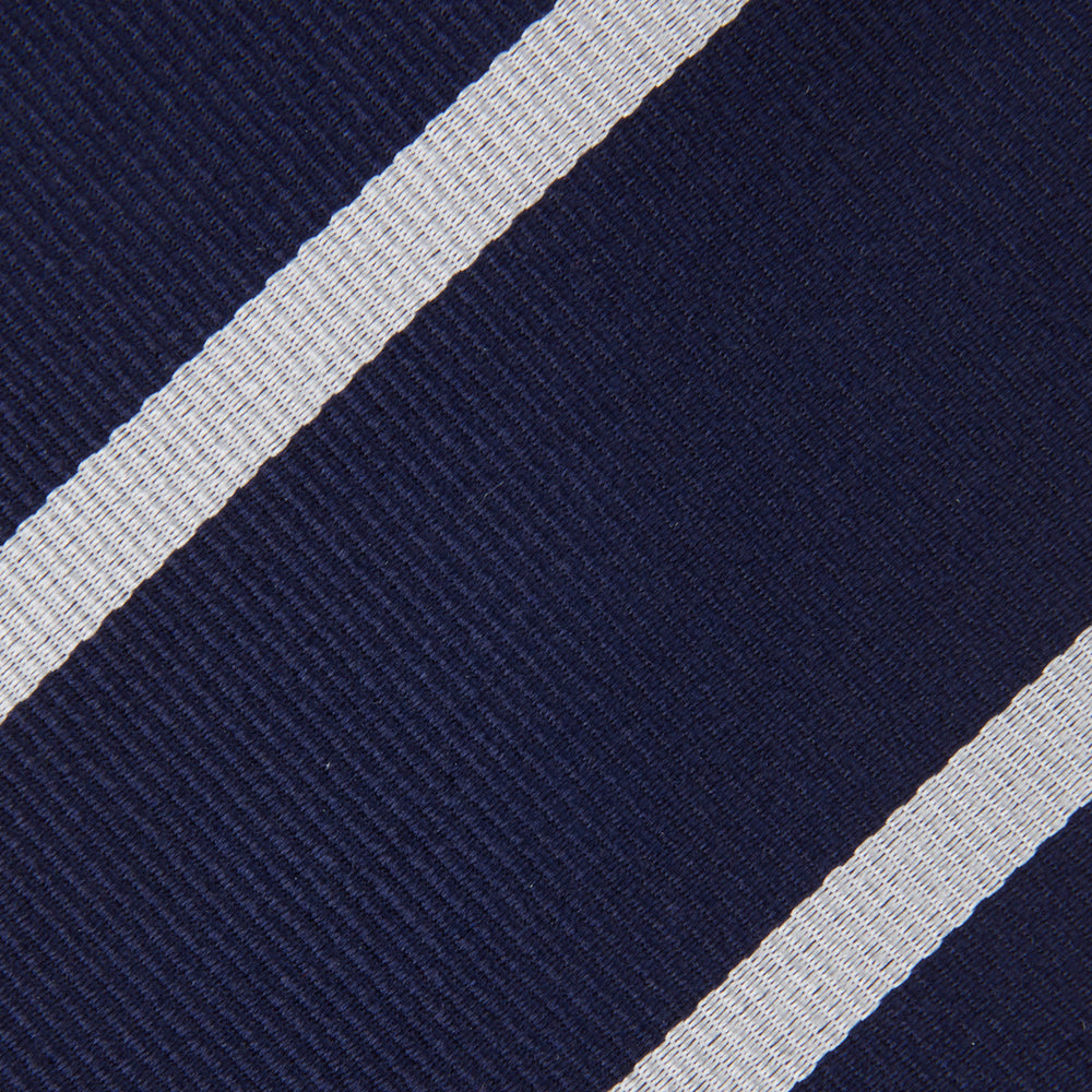 The Turnbull & Asser Navy and White Blazer Stripe Repp Silk Tie is shown rolled up on a plain white background—an ideal accessory to complement any office shirt.