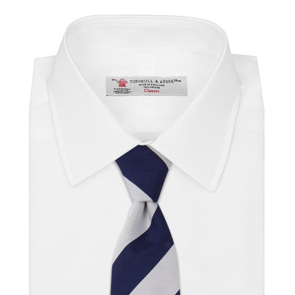 The Turnbull & Asser Navy and Off-White Block Stripe Repp Silk Tie features wide diagonal stripes, ideal for pairing with an office shirt against a plain light background.