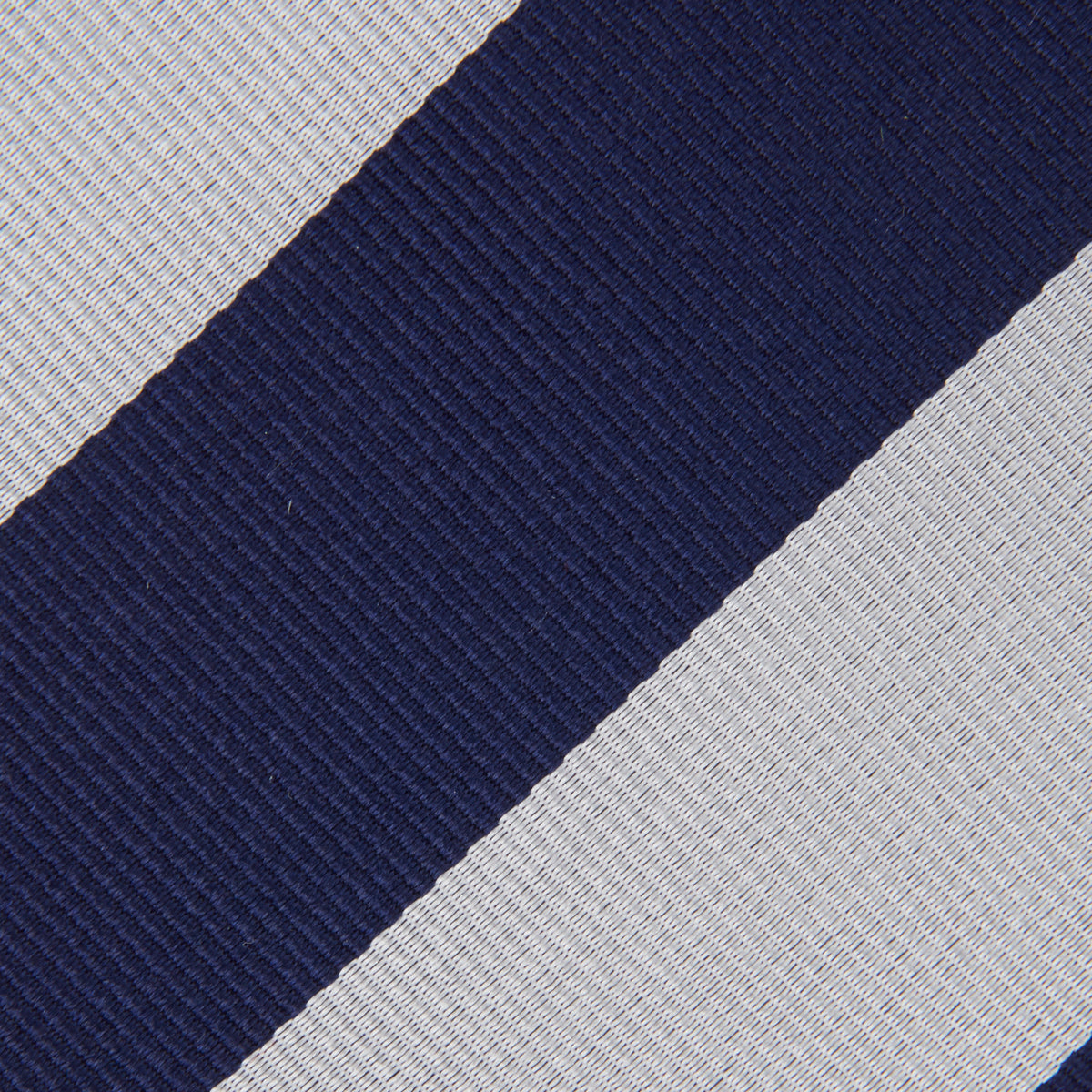 View 3 of product The Turnbull & Asser Navy and Off-White Block Stripe Repp Silk Tie features wide diagonal stripes, ideal for pairing with an office shirt against a plain light background.