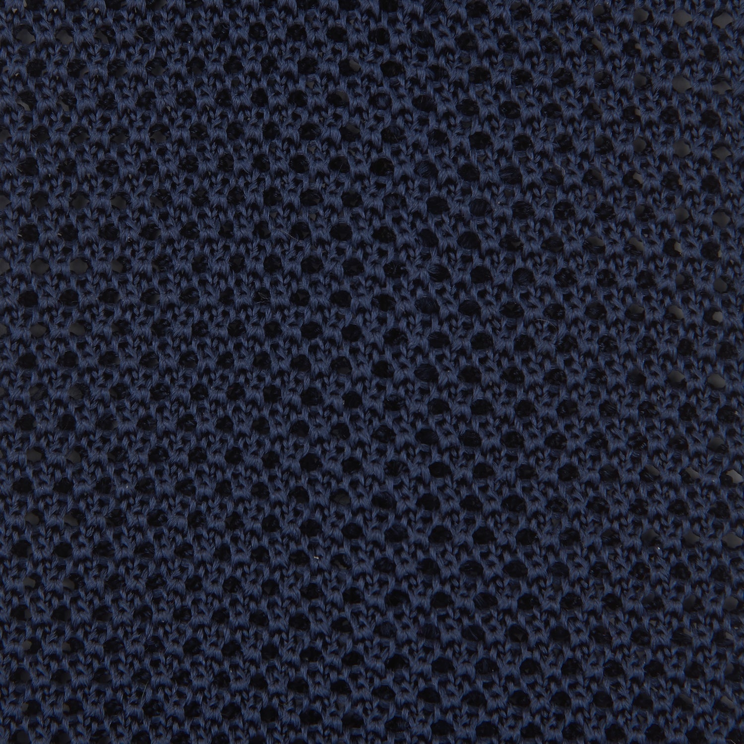 View 3 of product The Turnbull & Asser Navy Knitted Silk Tie features a textured open weave and flat squared ends, making it a versatile accessory for the modern gentleman’s wardrobe. Shown rolled up on a plain white background.
