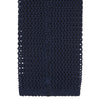 View 4 of product The Turnbull & Asser Navy Knitted Silk Tie features a textured open weave and flat squared ends, making it a versatile accessory for the modern gentleman’s wardrobe. Shown rolled up on a plain white background.