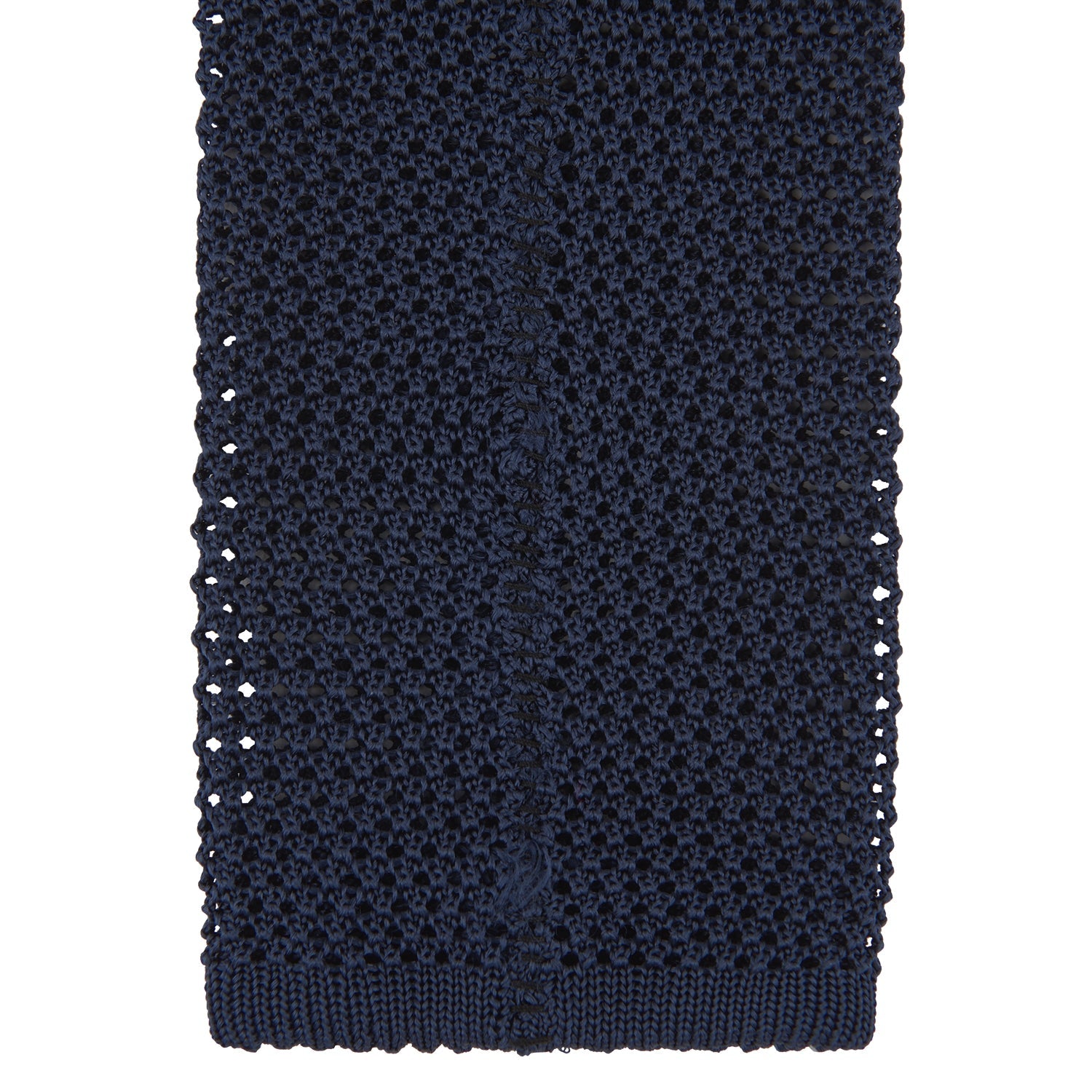 View 4 of product The Turnbull & Asser Navy Knitted Silk Tie features a textured open weave and flat squared ends, making it a versatile accessory for the modern gentleman’s wardrobe. Shown rolled up on a plain white background.