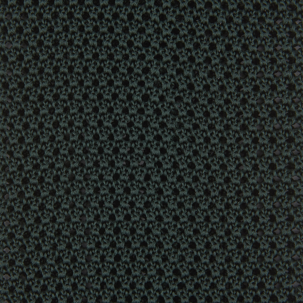 The Turnbull & Asser Green Knitted Silk Tie features a rich dark green hue and textured weave, making it an elegant accessory for any gentleman's wardrobe, shown rolled up against a light background.