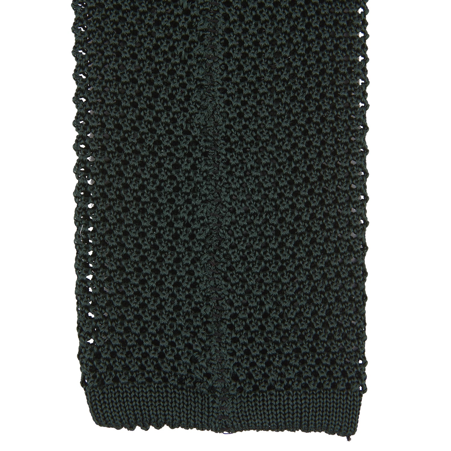 View 4 of product The Turnbull & Asser Green Knitted Silk Tie features a rich dark green hue and textured weave, making it an elegant accessory for any gentleman's wardrobe, shown rolled up against a light background.