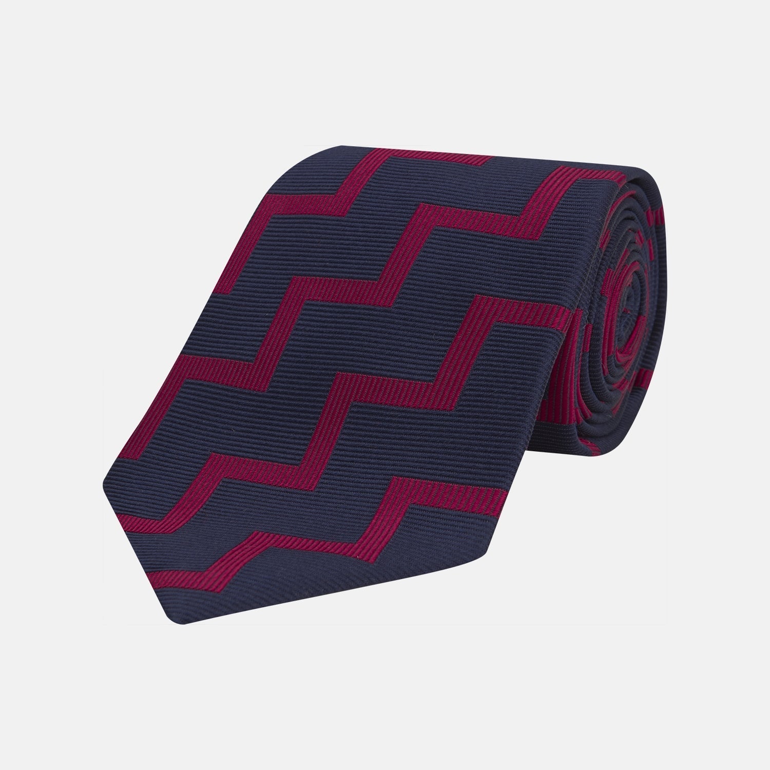 View 1 of product The Turnbull & Asser Navy and Red Striped Zigzag Silk Tie, featuring a striking pattern, is elegantly rolled on a white background—ideal for the modern gentleman.