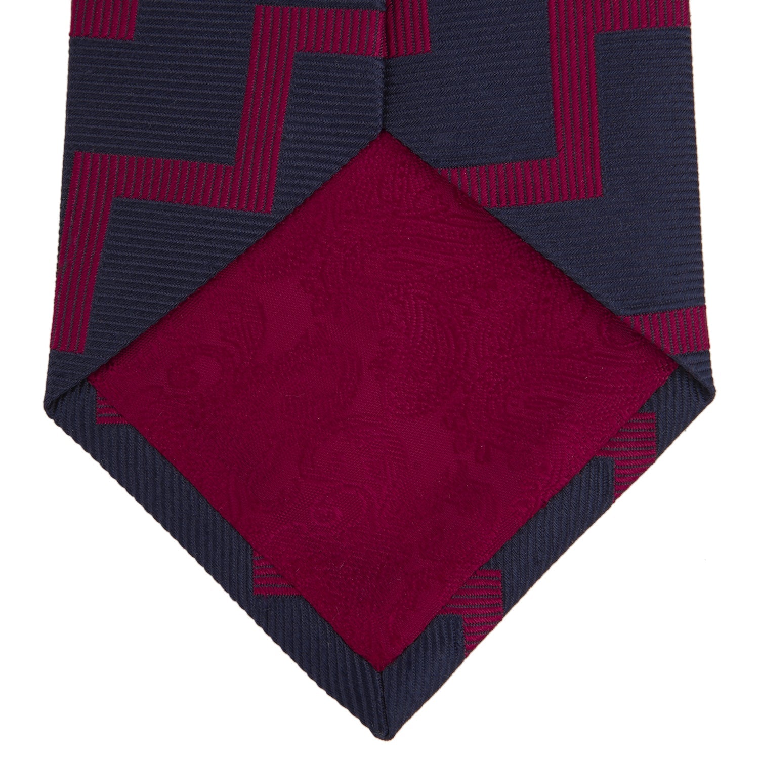 View 4 of product The Turnbull & Asser Navy and Red Striped Zigzag Silk Tie, featuring a striking pattern, is elegantly rolled on a white background—ideal for the modern gentleman.