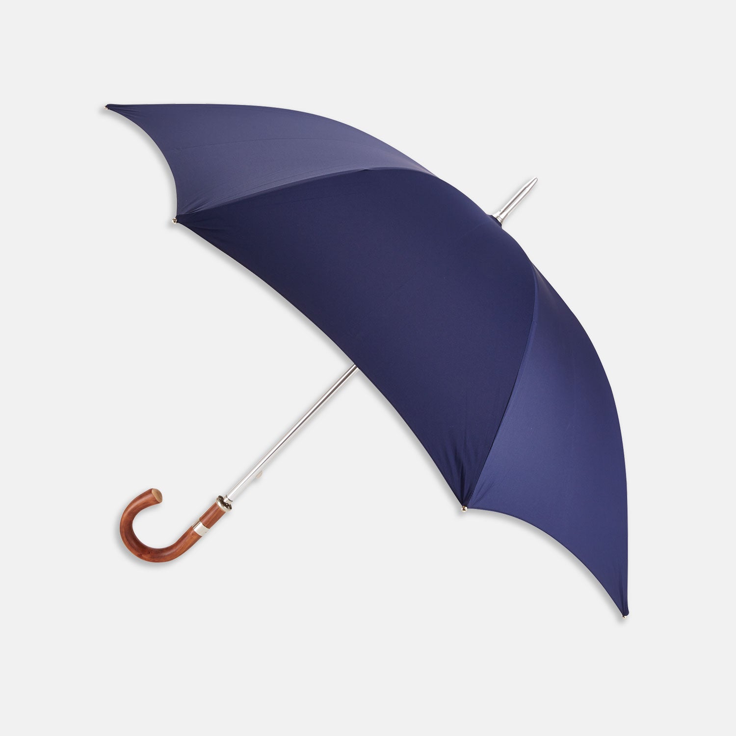 View 1 of product The Turnbull & Asser Navy Umbrella with Chestnut Crook features a curved wooden handle and silver metal shaft, designed for durability in English weather and shown against a plain white background.