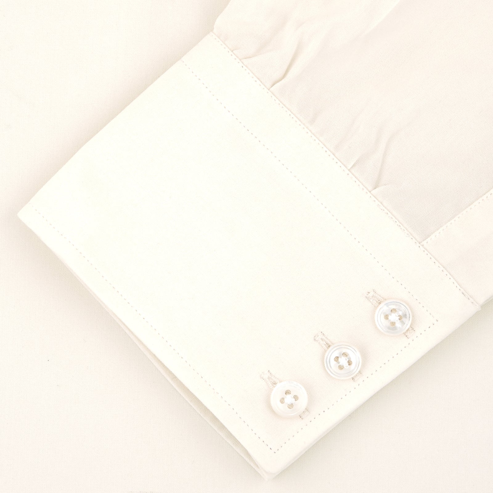View 5 of product The Cream Silk Shirt by Turnbull & Asser features a T&A collar and 3-button cuffs, displayed folded on a light background—perfect for sophisticated evening wear.