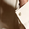 View 5 of product The Turnbull & Asser Tailored Fit Cream Pleated Front Silk Dress Shirt with T&A collar and double cuffs is displayed neatly folded against a light gray background.