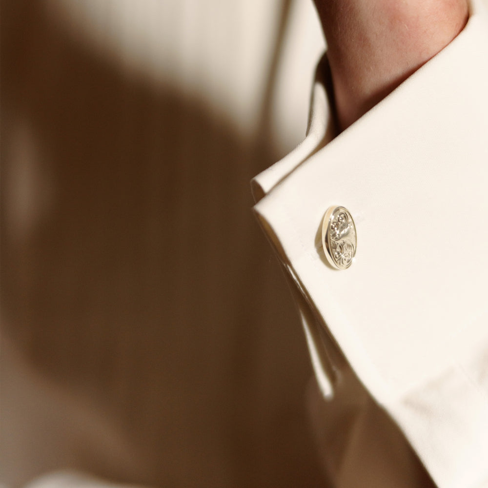 The Turnbull & Asser Tailored Fit Cream Pleated Front Silk Dress Shirt with T&A collar and double cuffs is displayed neatly folded against a light gray background.