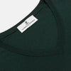 View 2 of product The Turnbull & Asser Forest Green Fine Merino V-Neck Jumper, shown laid flat on a white background, features classic Scottish knitwear details with ribbed cuffs and hem for a timeless look.