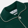 View 2 of product The Turnbull & Asser Dark Green Silk Pyjama Set features a long-sleeve button-up top with white piping, chest pocket, and matching pants, all neatly folded on a plain white background.