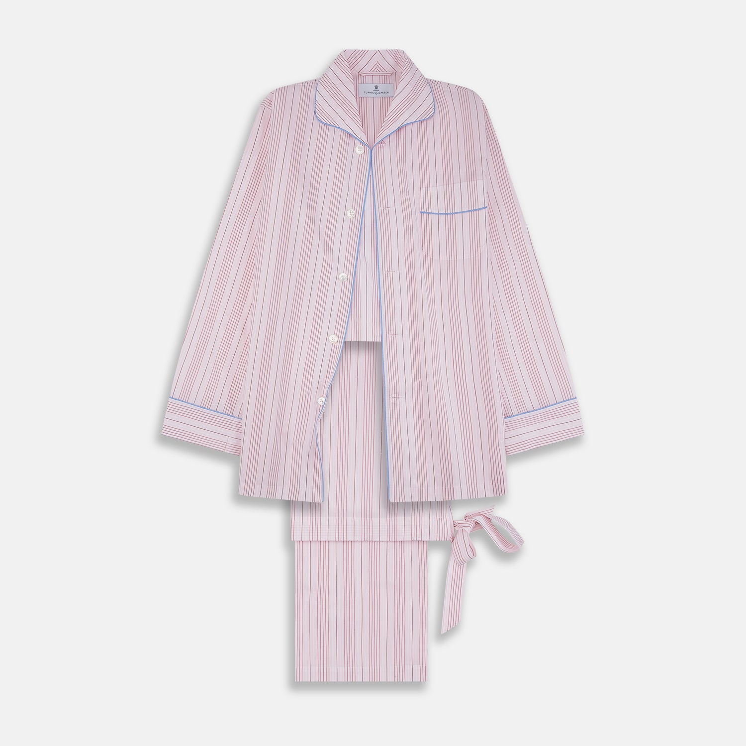 View 1 of product The Turnbull & Asser Pink And White Stripe Twill Cotton Pyjama Set features long sleeves and pants with a curved collar and blue trim on the cuffs, pocket, and hem—a classic gent’s style shown on a plain white background.