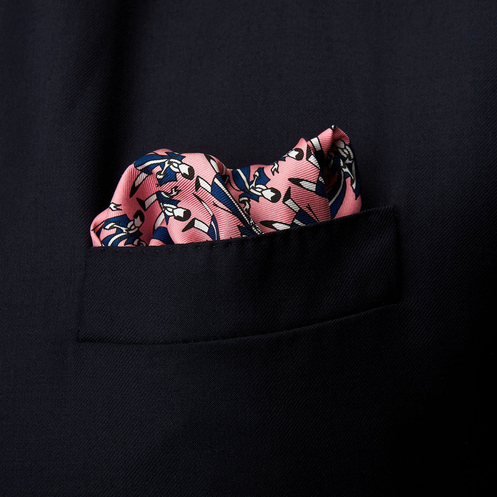 The Pink Dressing Gowns Pocket Square by Turnbull & Asser features a pink base inspired by classic dressing gowns, with black and white illustrated golfers in swinging poses and navy and pink striped borders.