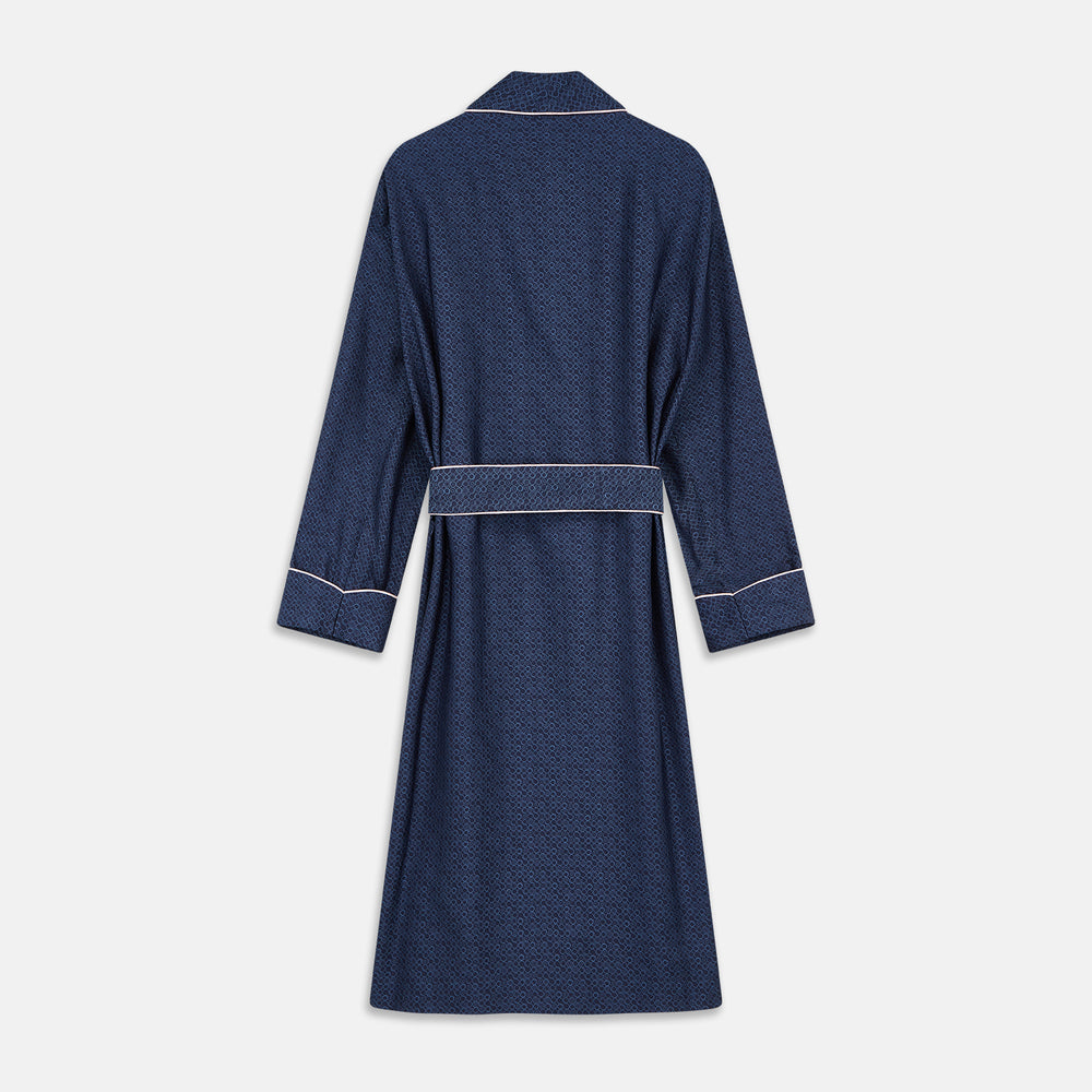 The Turnbull & Asser Blue Multi Circle Silk Jacquard Gown features a subtle geometric pattern, white piping, a chest pocket, and a matching waist belt, all showcased against a white background.