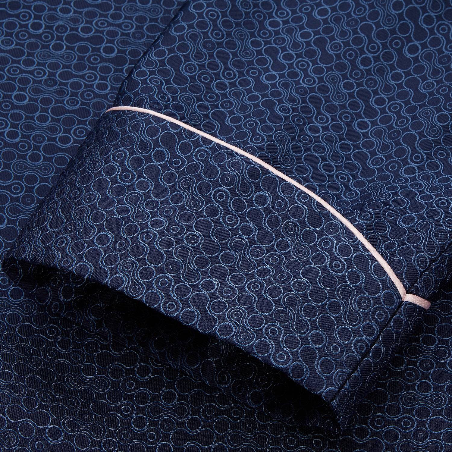 View 3 of product The Turnbull & Asser Blue Multi Circle Silk Jacquard Gown features a subtle geometric pattern, white piping, a chest pocket, and a matching waist belt, all showcased against a white background.