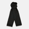 View 1 of product The Turnbull & Asser Black & White Spot Superfine Cashmere Scarf features evenly spaced white dots, lightly frayed edges, and a lightweight design for subtle elegance in any outfit. Shown laid flat with a loose knot at the top.