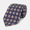 View 1 of product The Turnbull & Asser Burgundy Geometric Jacquard Tie features a bold, playful pattern of red and white dice scattered across its surface.