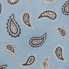 View 3 of product The Turnbull & Asser Sky Blue Renoir Paisley Tie, crafted in silk with a repeating navy and beige pattern, is shown rolled up with its pointed end forward on a plain white background.